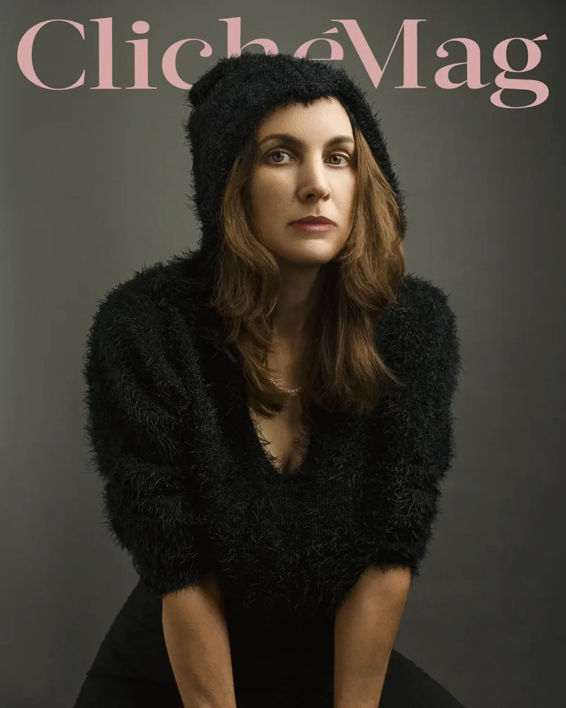 Cliche magazine cover. Woman wearing a fuzzy hooded jacket on a dark background.