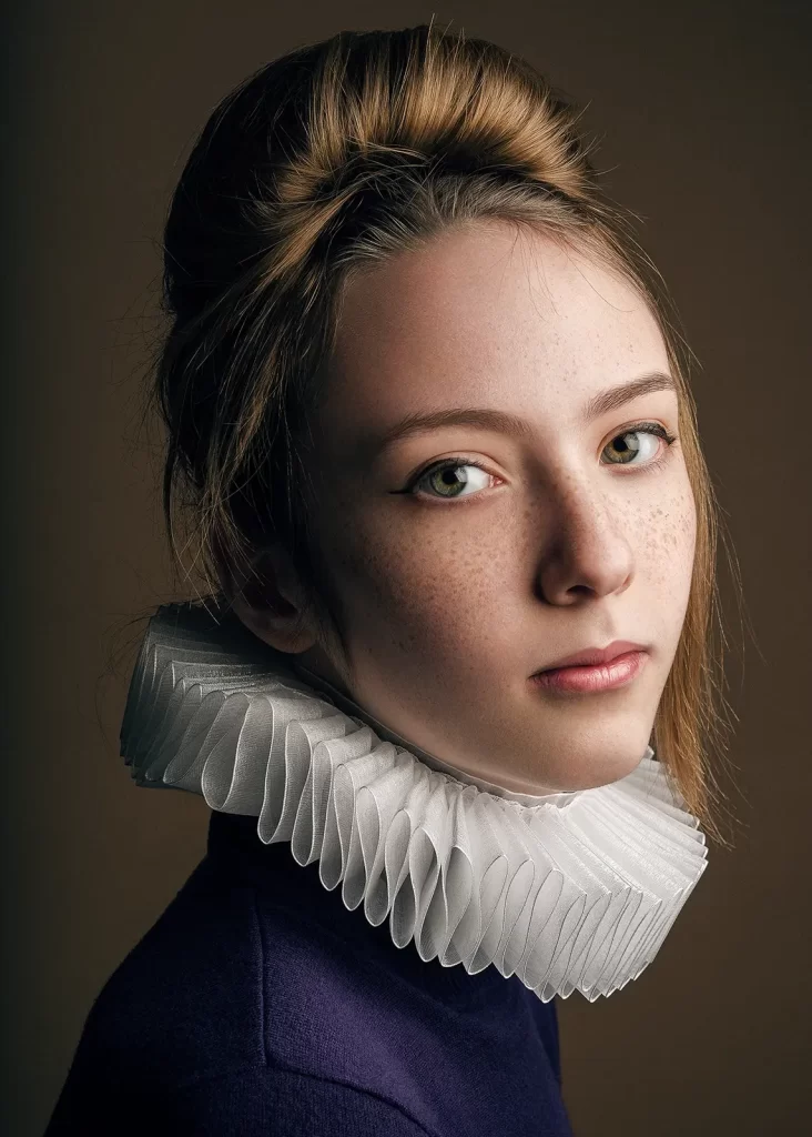 Teenage girl wearing a purple sweater and a ruff like Shakespeare.