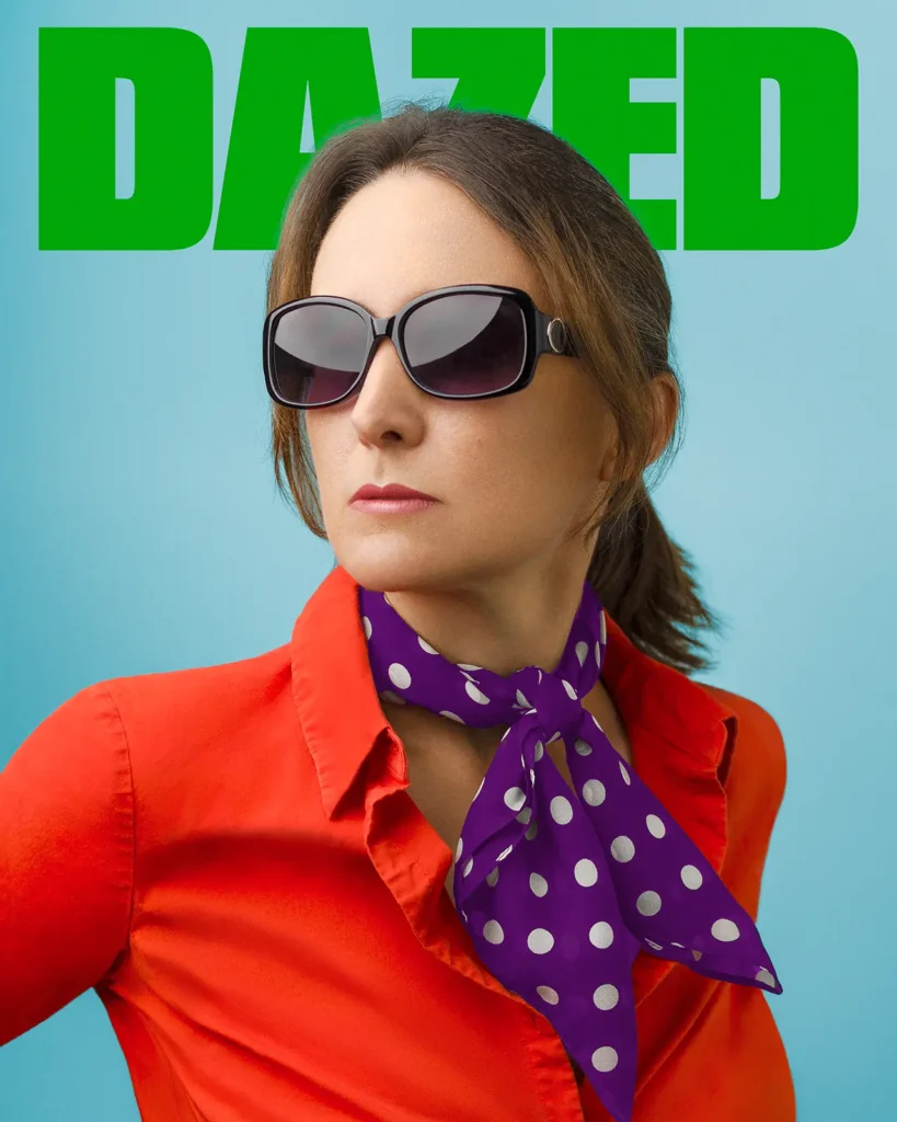 Dazed magazine cover. Woman wearing an orange blouse with a purple polka dot scarf on a light blue background.