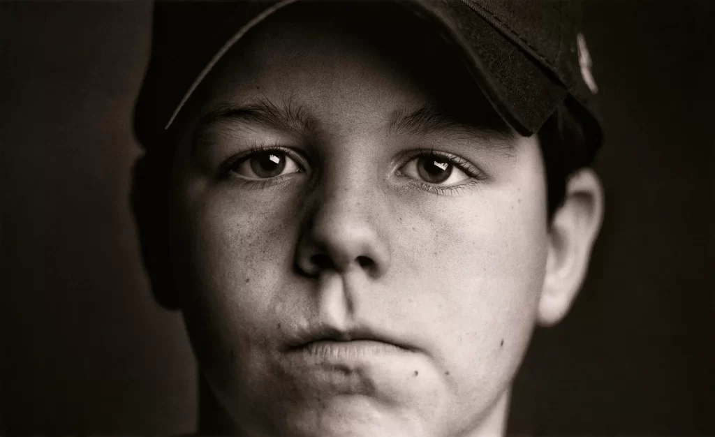 Close-up black and white portrait of a little league baseball player. Michael.