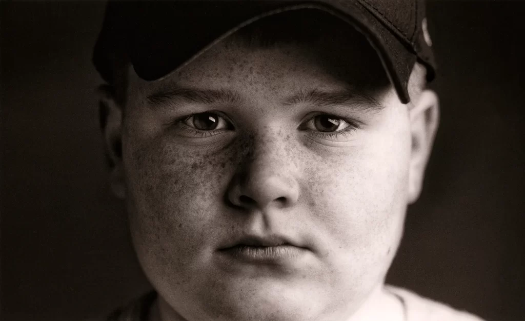 Close-up black and white portrait of a little league baseball player. Isaac.