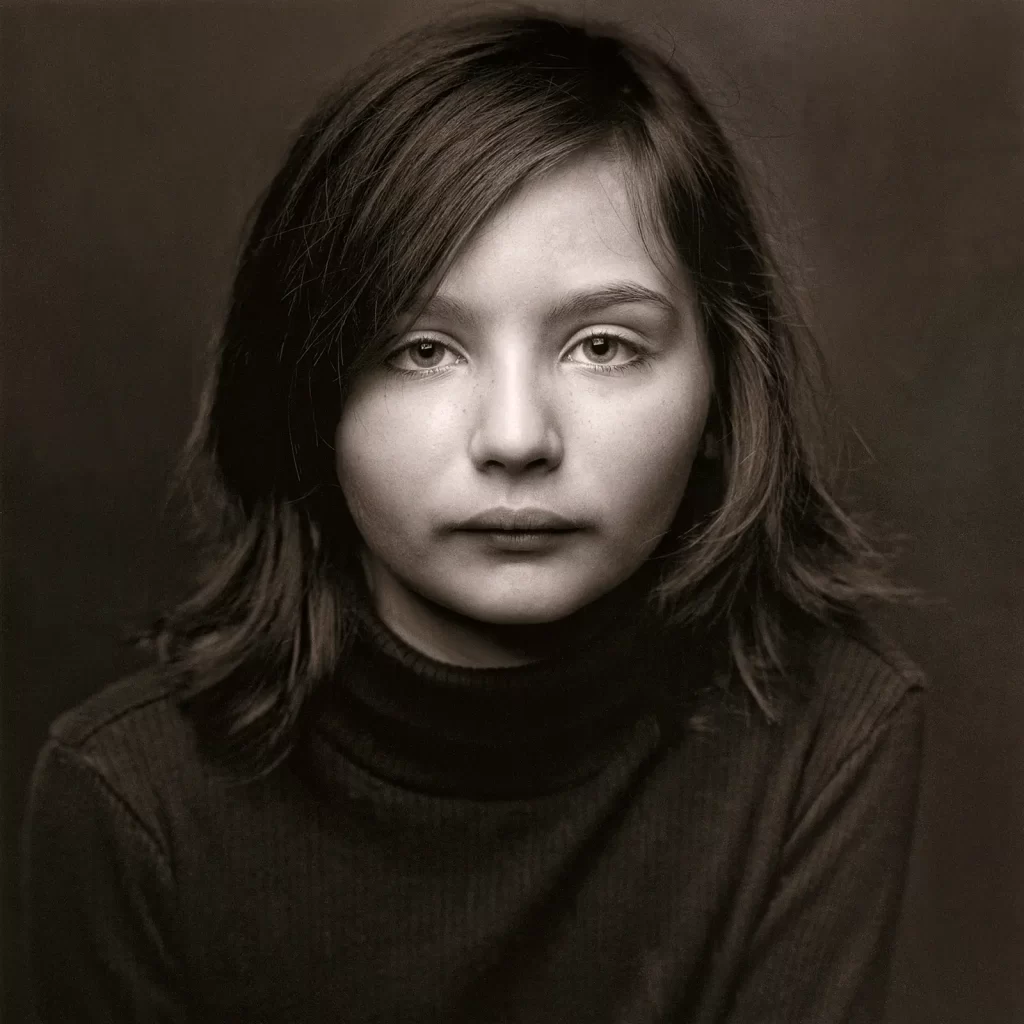 Black and white portrait of a young girl wearing a black turtleneck sweater.